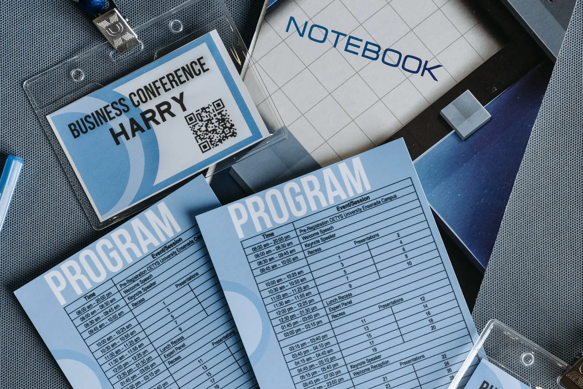 Druk wielkoformatowy, materiały szkoleniowe, notes, program szkolenia, identyfikator w jednej kolorystyce położone na blacie