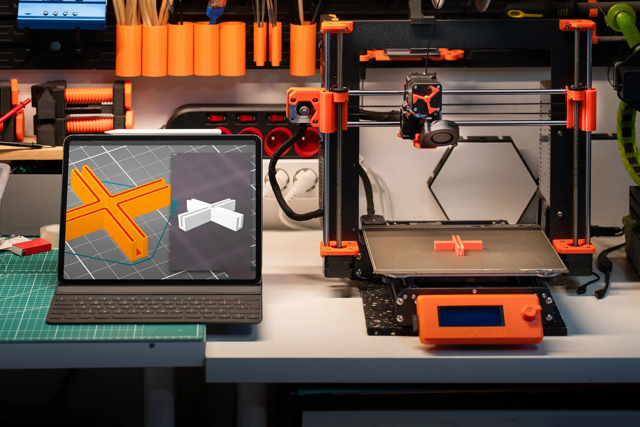Drukarka 3D w trakcie druku i model na ekranie laptopa